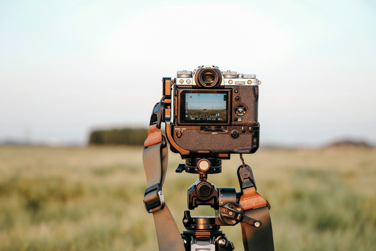 A mirrorless camera mounted on a tripod set up for night photography